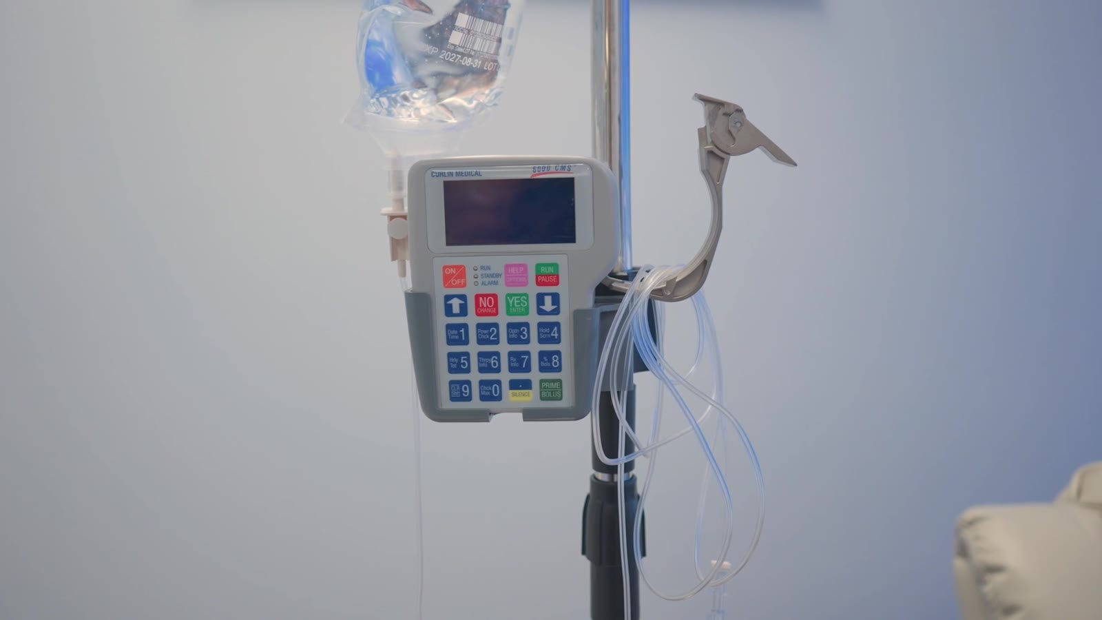 An infusion pump on an IV pole beside a recliner at a ClinIVoy clinic