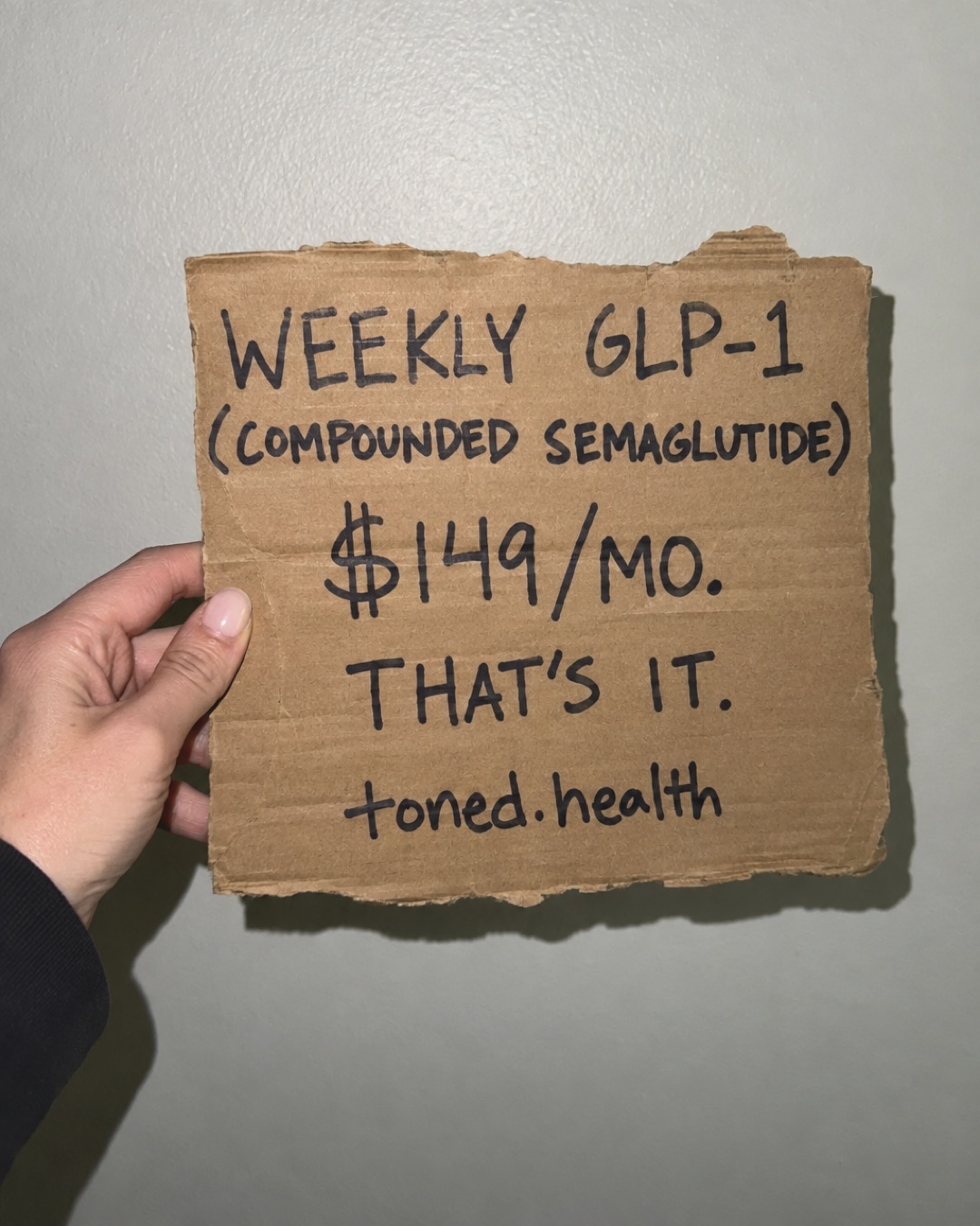 Toned.health static ad, a hand-held cardboard sign, "Weekly GLP-1, $149 a month, that's it"